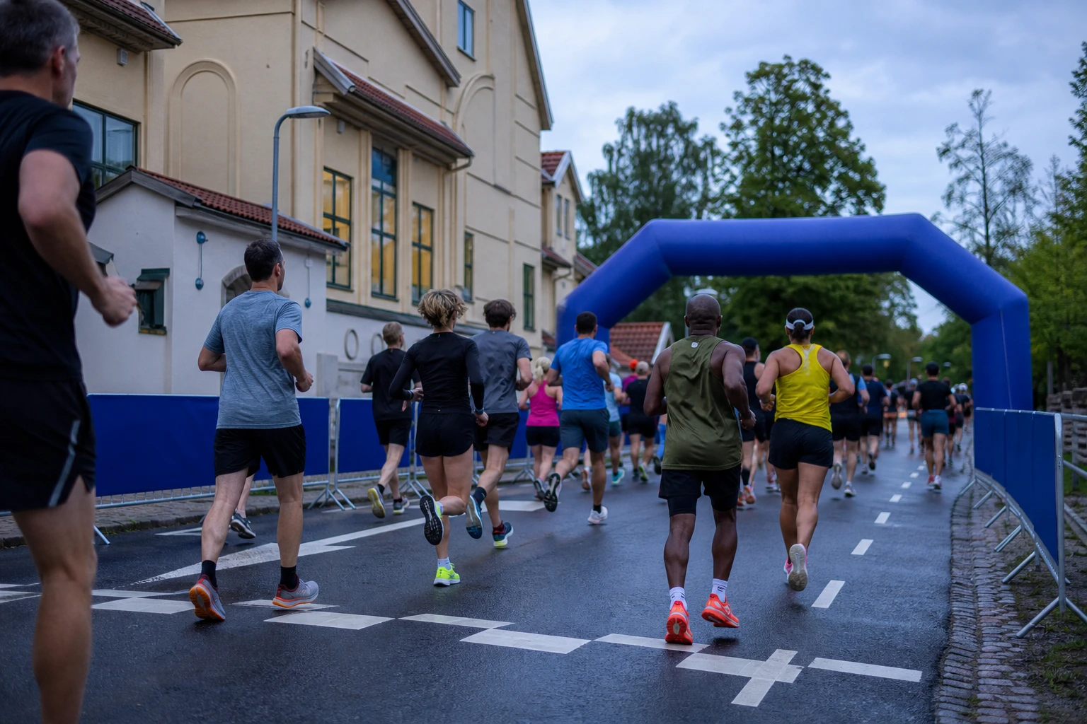 Tätt startfält av motionslöpare på asfalt