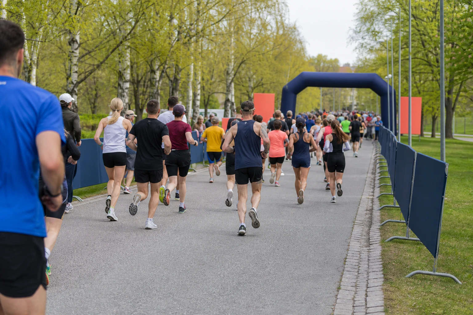 Tätt startfält av motionslöpare på asfalt