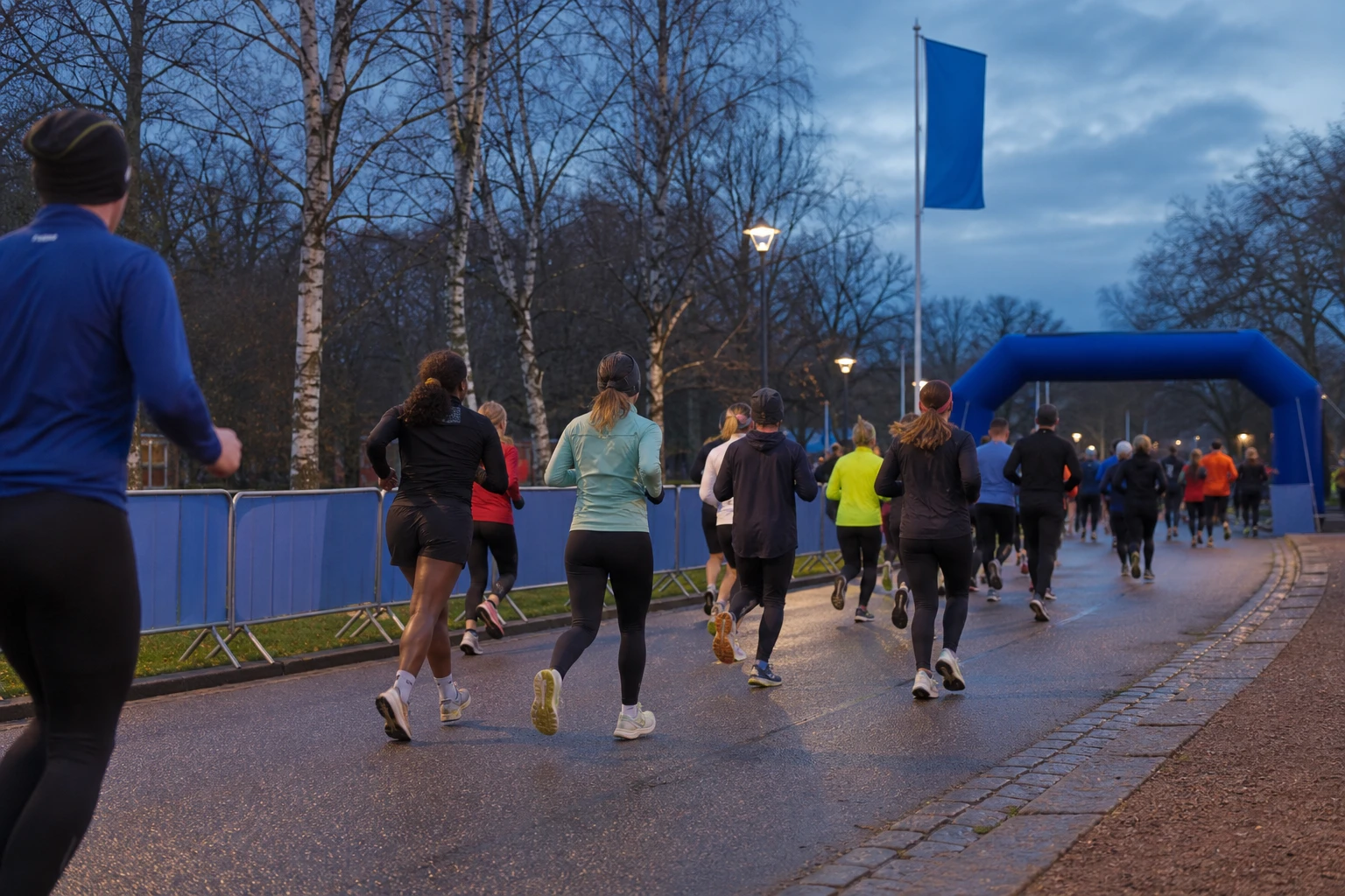 Tätt startfält av motionslöpare på asfalt