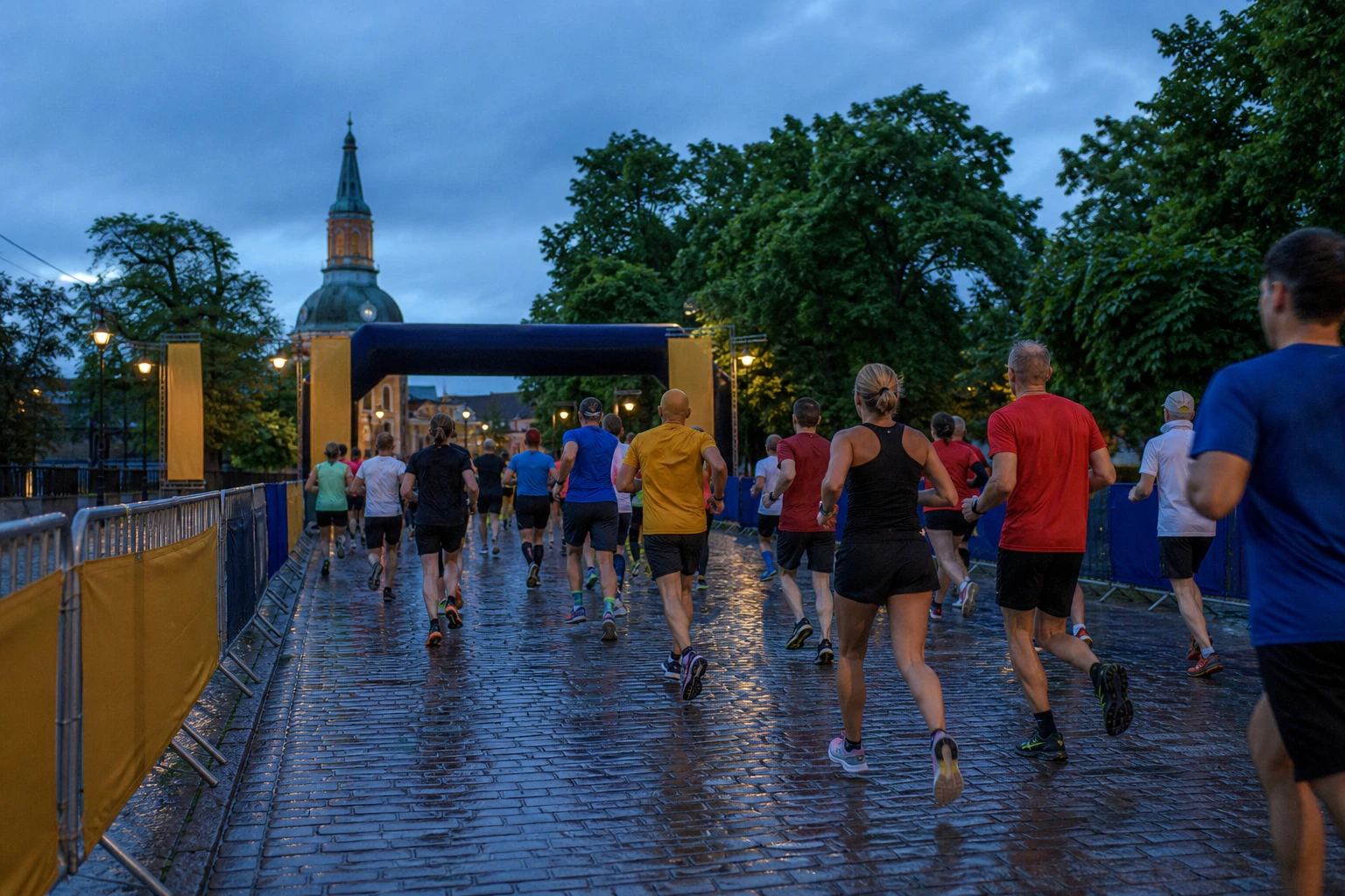 Tätt startfält av motionslöpare på asfalt